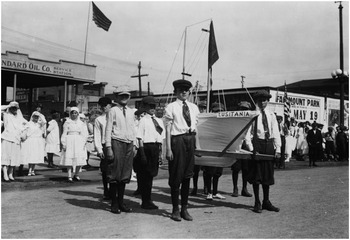 A photo of several boys standing at attention in the middle of the street during an American Red Cross parade in Kansas City, Missouri, May 18, 1918. See long description.
