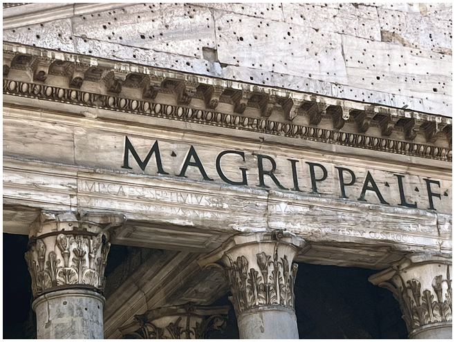 A close-up view of the white marble architrave above the columns of the Pantheon shows an inscription. It reads, M AGRIPPA L F, in large capital letters. Below, 2 lines of text inscribed text appear, some of which are illegible due to weathering.