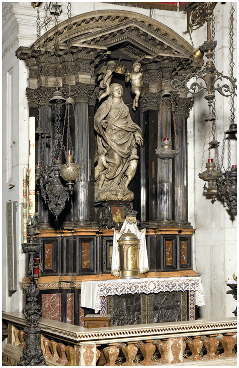 An elaborate architectural niche with Corinthian stone columns on both sides. A large white marble sculpture of the Virgin Mary is in the center niche. There is an altar below, decorated with two silver panels in relief.