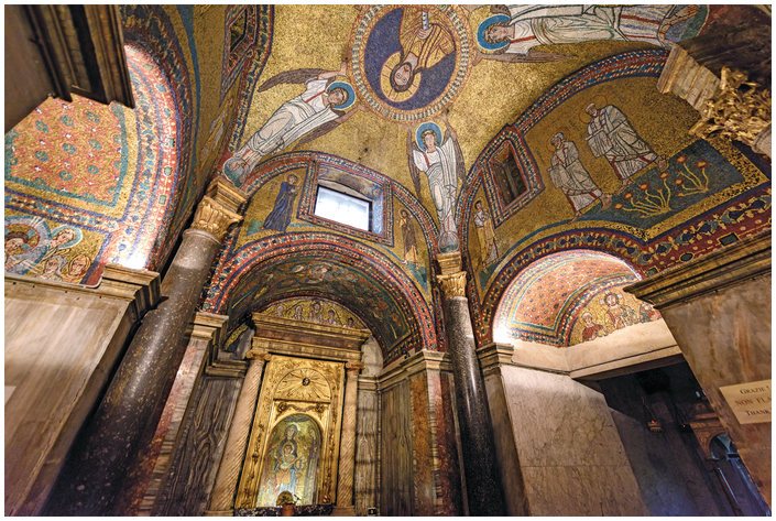 The chapel's walls and ceiling are completely covered with gold and multi-colored mosaics. Each of the three visible walls has a rounded archway. Christ's bust-length mosaic portrait is at the center of the ceiling, held aloft by four mosaic angels.