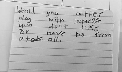 A child’s handwriting on lined paper reads: Would you rather play with someone you don’t like or have no friends at all. There are numerous spelling mistakes and words crossed out.