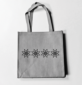 A tote bag has been printed with five small selburose designs in a horizontal line. The designs have thin borders and no fill.