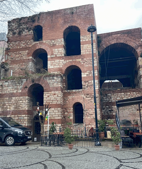 A front view of the staircase known as the Ramp House. It is the only standing building from the Upper Palace. It features several levels with arched windows and is built in brick.