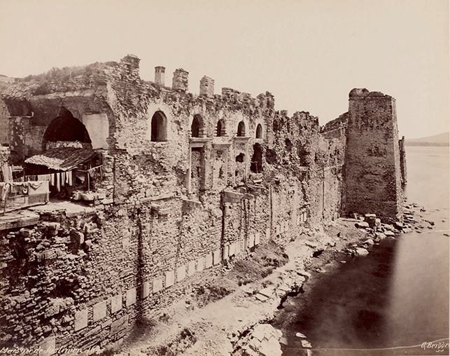 A photograph of the arched loggia known as the House of Justinian, around 1880. In the background, the Lighthouse tower can be seen.