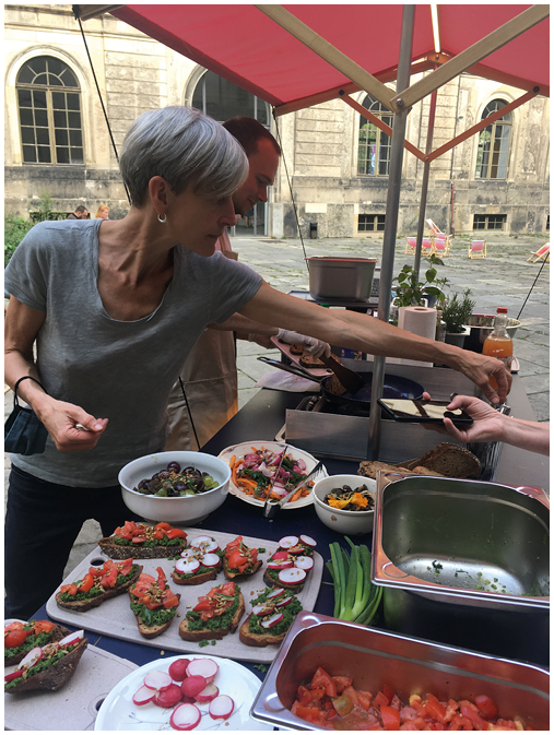 Image showing outdoor food-sharing with freduce produced and prepared dishes as urban sustainability initiative.