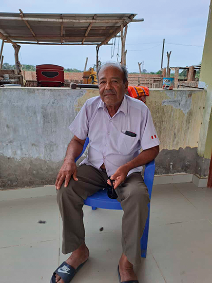 Don Augusto Granados seated in front of his home, facing the camera.