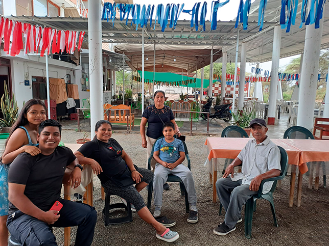 The Chapoñán family in their restaurant; Milagros is seated center with her children and uncle, Doña Clotilde stands behind them.