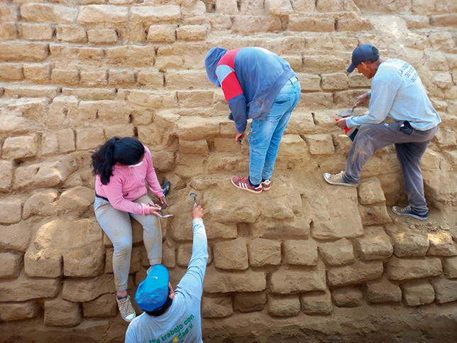Don Damian and Nayo instructing a student on identifying adobe bricks at the huaca’s western façade.