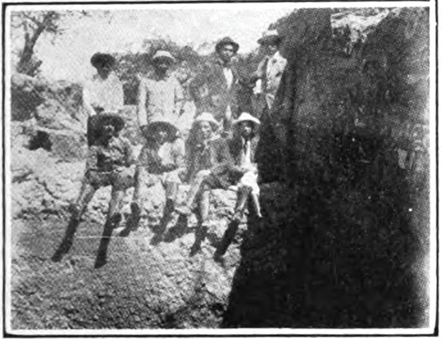 A portrait of looters who uncovered the murals of Huaca Pintada, taken before official excavations began. Four of them are seated on a rock, and the other four are standing behind them.