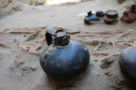 A mutilated Huaco Rey figure beside a second burial raising questions about ritual intent.