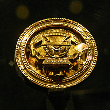 A gold earring from the Lambayeque culture, featuring a depiction of the main deity; housed in the Brüning Museum.