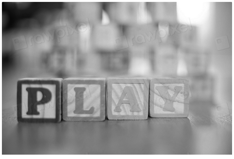Photograph of toy blocks spelling out play.