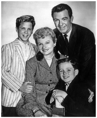 Images taken in the 1950s of a smiling white family posed together. See long description.