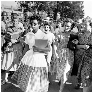 Images taken in the 1950s illustrate a young Black girl surrounded by a hostile crowd. See long description.