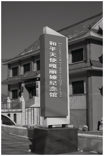 Entrance stone of the Memorial Museum of Galina Dubeeva bearing the inscription "Angel of Peace Galya Memorial Museum" and a portrait of Galya in the museum.