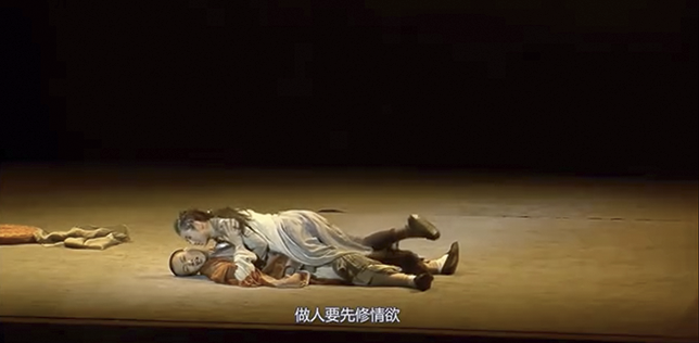 In a stage scene from Green Snake, Little Green lies on top of Monk Fa Hai, her body pressing firmly against his as he struggles beneath her. Her forward-leaning posture and intent gaze convey power and desire.