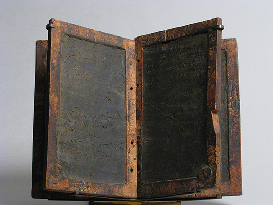 Wooden tablets with frames to contain the incised wax-surface in the center, previously bound together to form a codex.