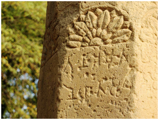 Photograph of a stone inscription on a pillar, in Prākrit.