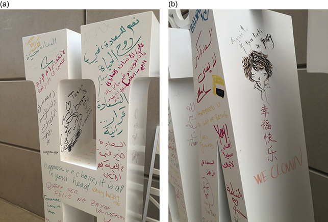 Close-ups of a sculpture that spells Happiness. See long description.