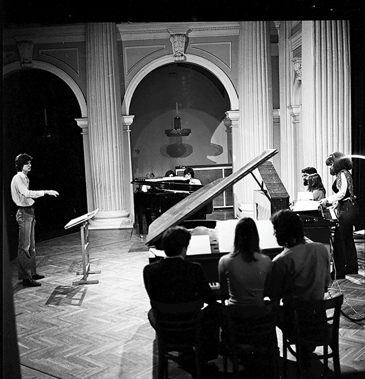 Miloš Raičković conducting the Ensemble for Different New Music during the debut performance of his piece Permutations on 7 December 1977 at the Student Cultural Center in Belgrade. See long description.