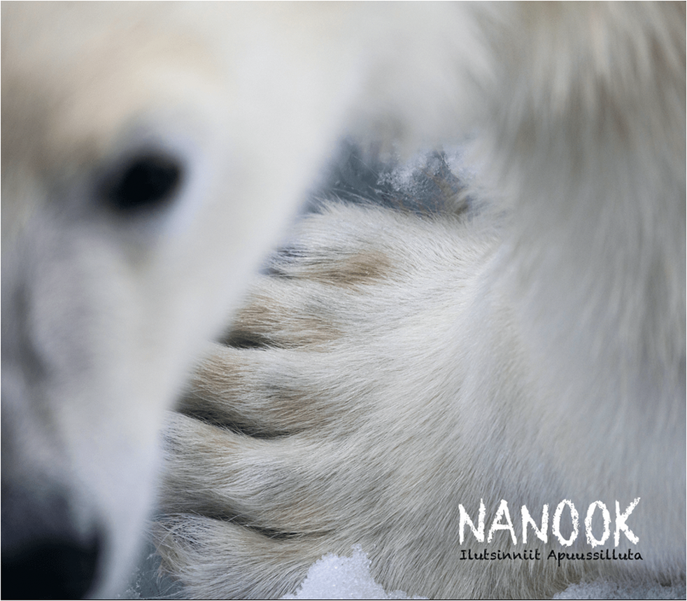 Photo of a close-up polar bear paw with blurred face at left and the text NANOOK Ilutsinniit Apuussilluta at the lower right.