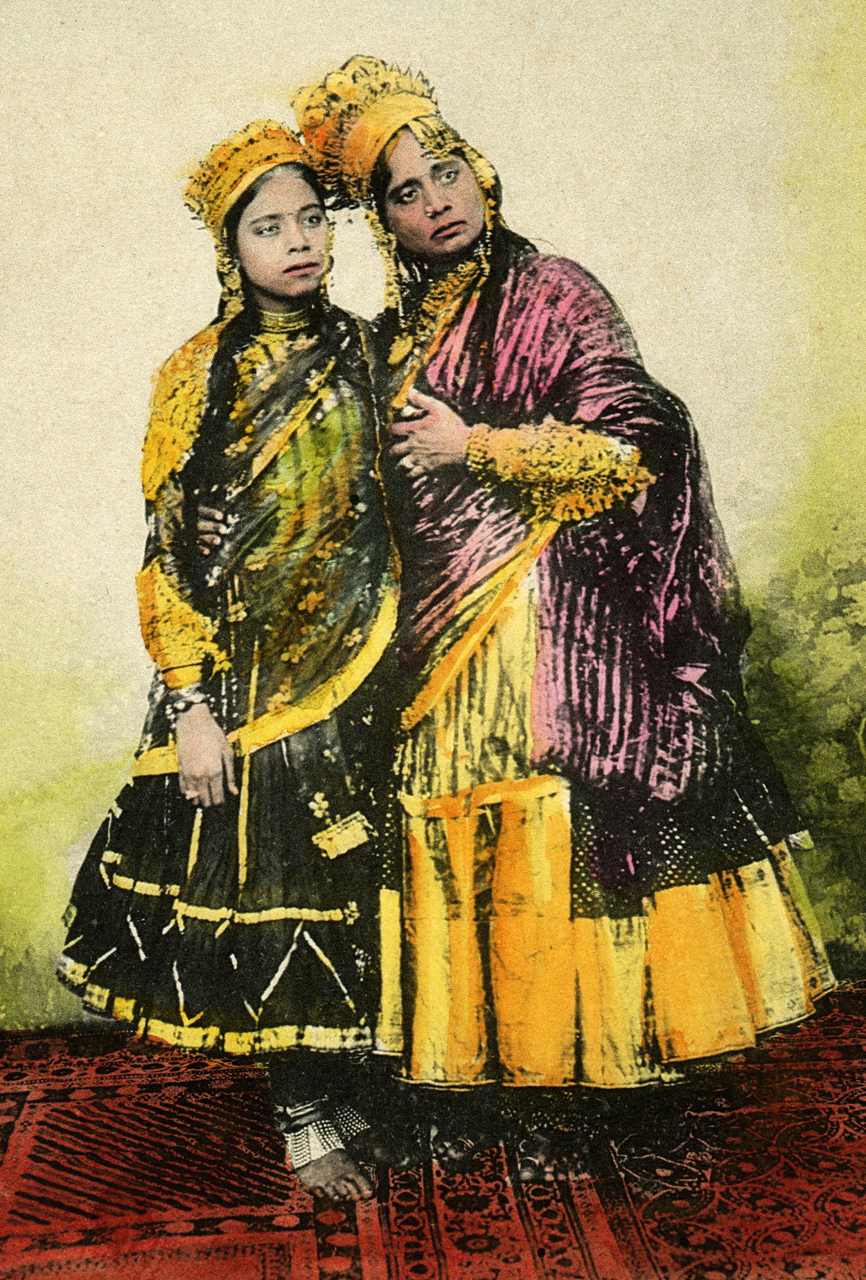 Nanhi Jan with a younger performer, both wearing crowns and traditional attire. See long description.