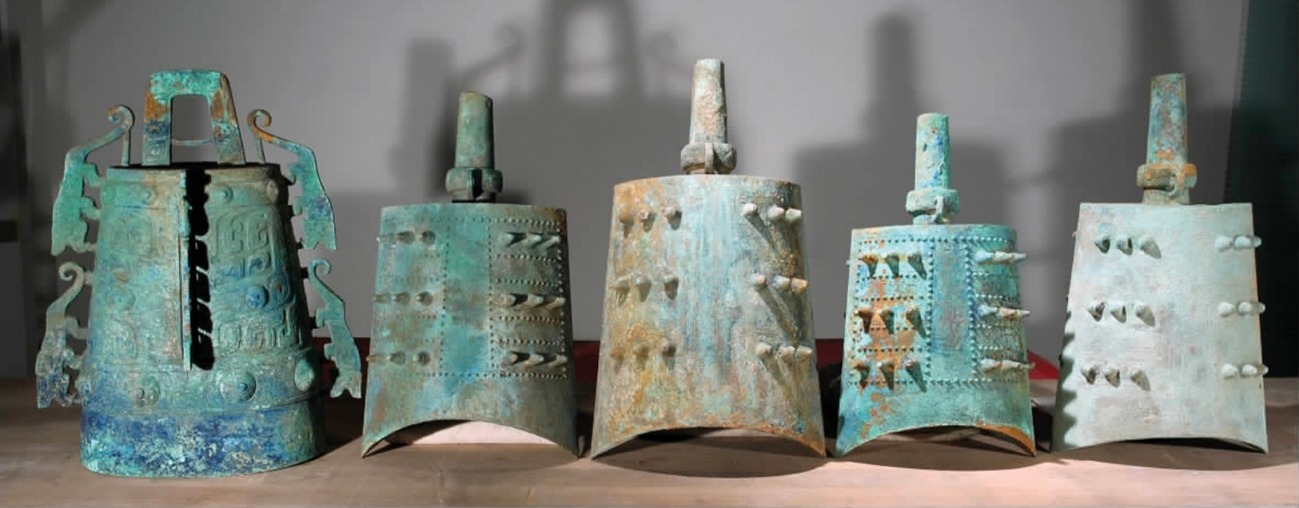 Five ancient bronze bells with intricate designs and varying sizes.