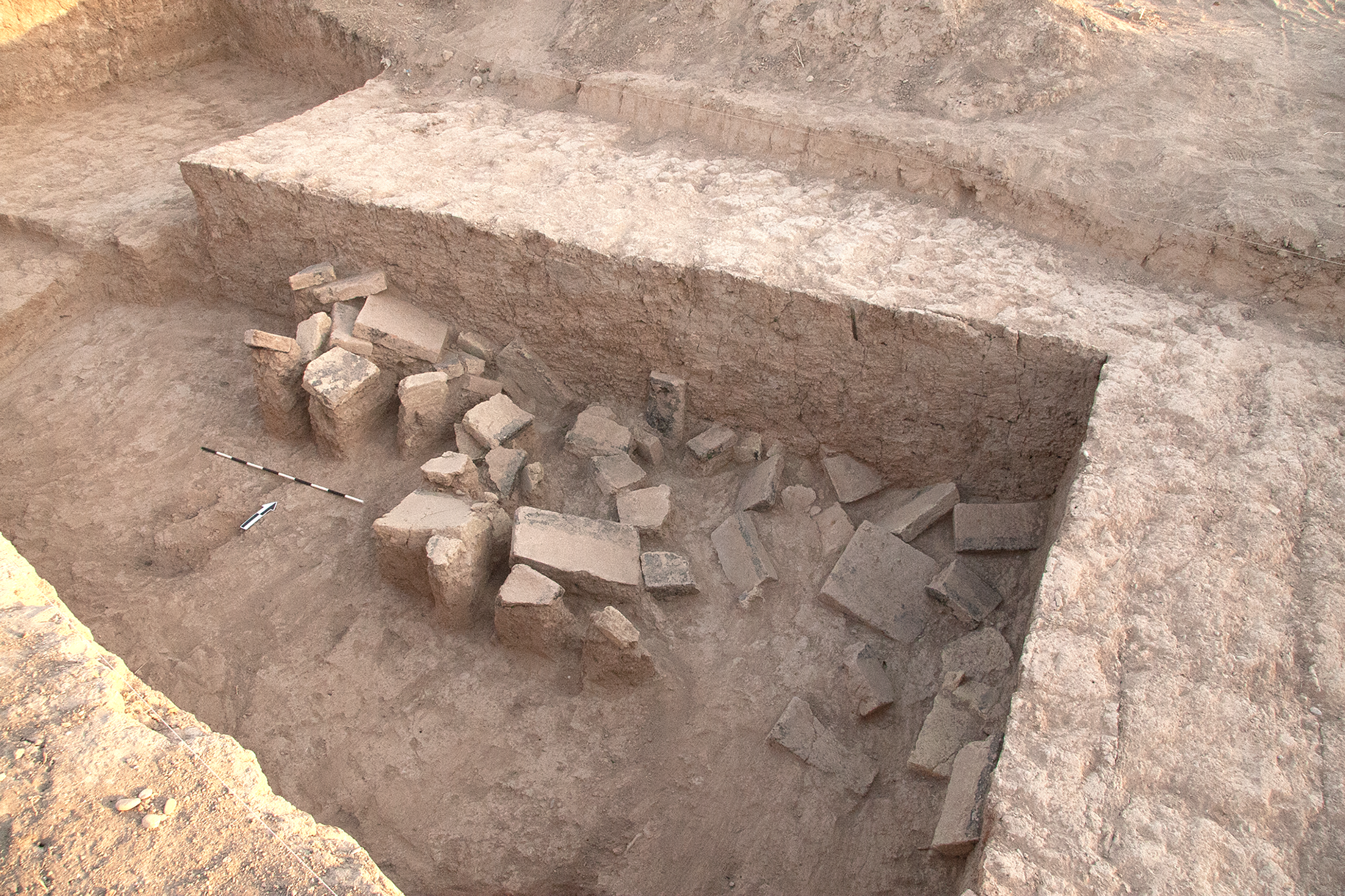 Excavated area with scattered bricks and fragments.