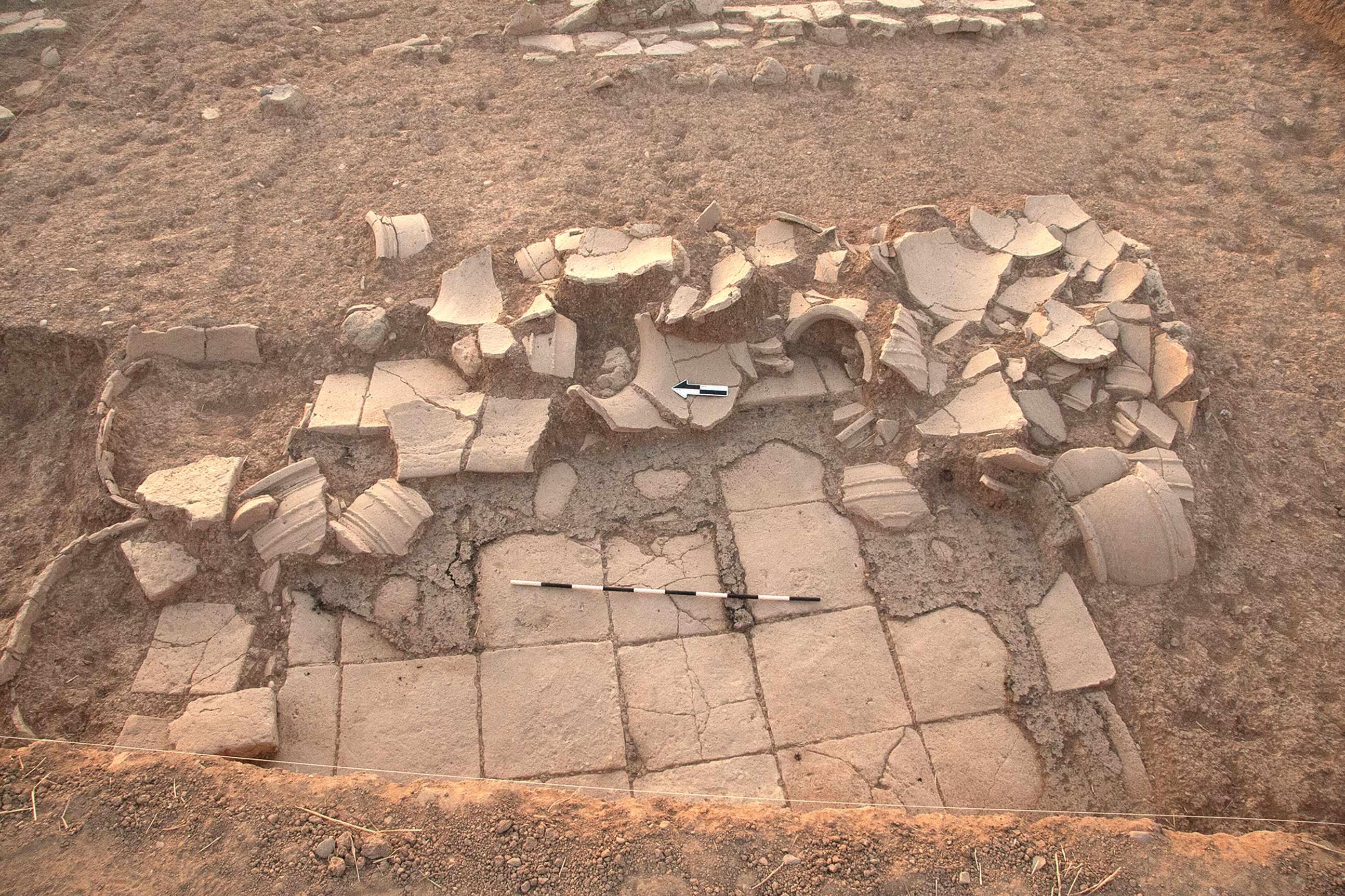 An archaeological excavation site with visible stone and brick remnants.