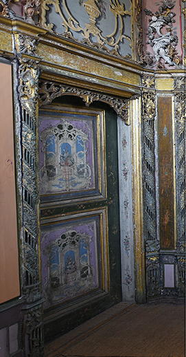 A grainy 1960s photograph of a doorway leading to a small nook, with a calligraphic medallion above the door.