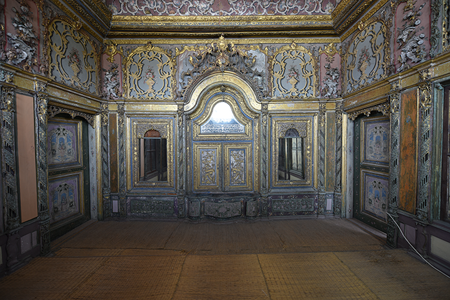 Interior view of the alcove-like tripartite mirrored wall in Selim III’s lihye room. The central arched niche and side mirrors are framed with gilded Rococo carvings, floral reliefs, and painted panels in different shades.