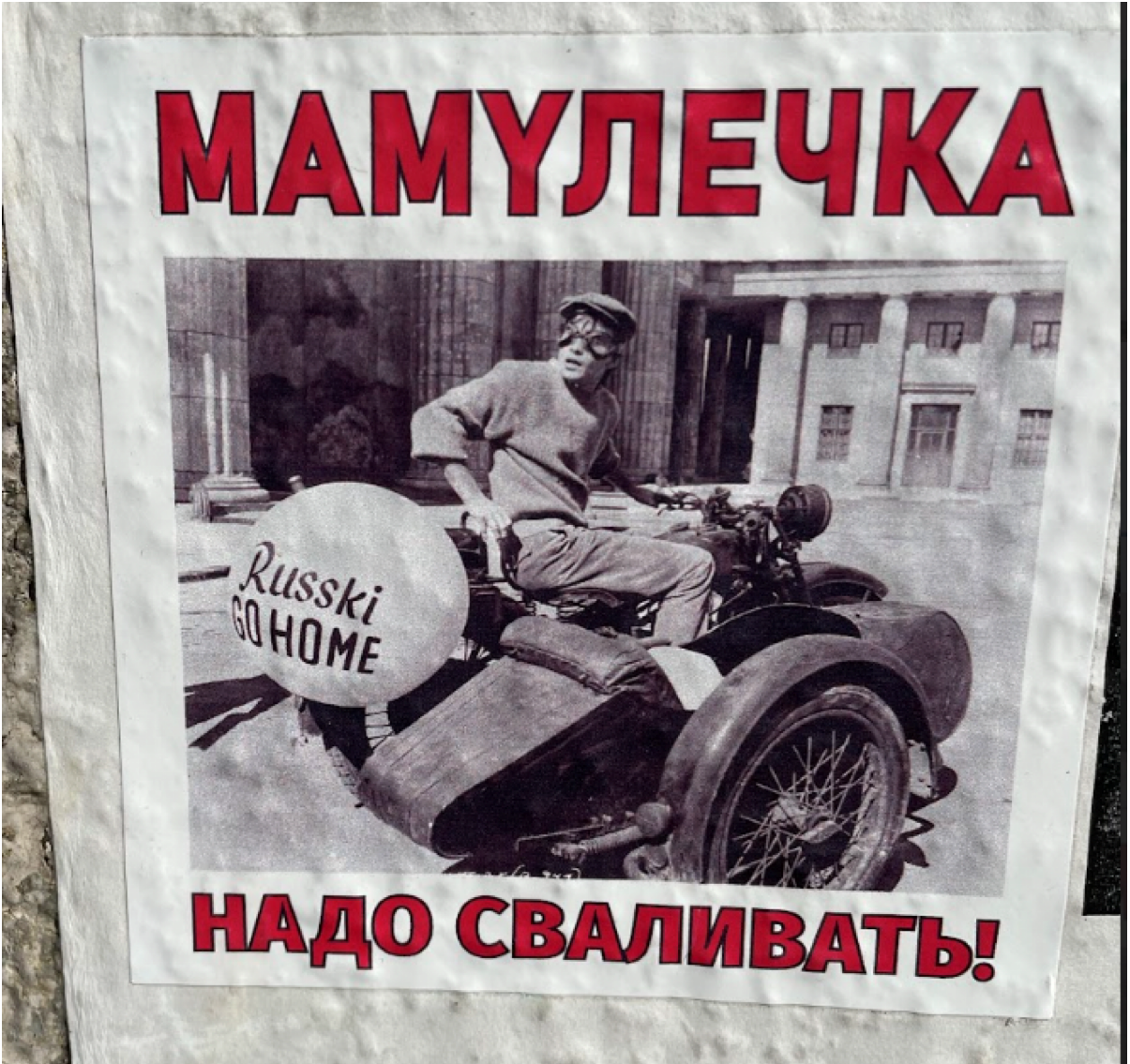 Poster with red Cyrillic text at the top and bottom. A central black and white photo shows a man on a motorcycle with a sidecar. A white balloon attached to the back reads Russki G O H O M E in black cursive and block letters.