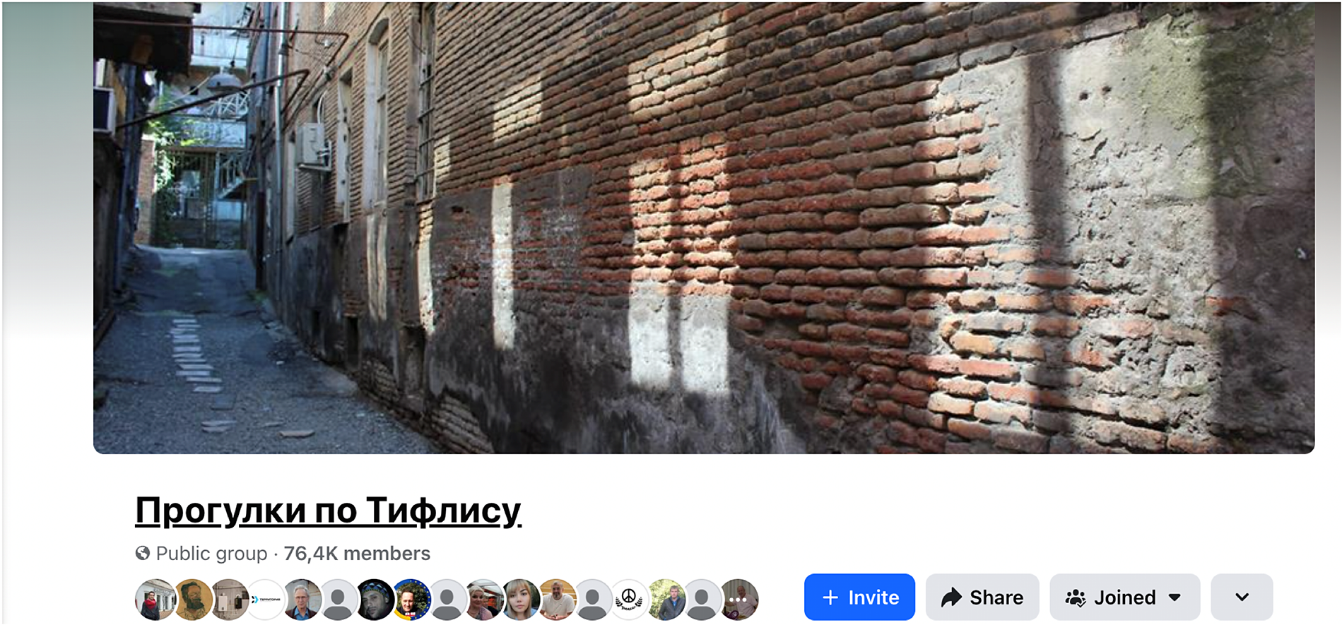 A screenshot of a Facebook group page. A banner photo shows a narrow alleyway with a textured brick wall. Below, the title is in Cyrillic text followed by group details and blue interaction buttons.