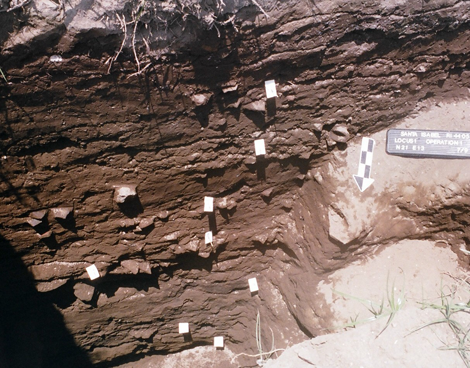 Stratified excavation site with labeled layers and a measuring scale. See long description.