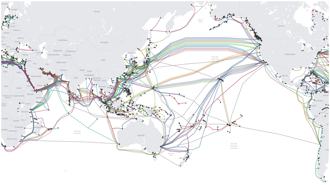 Map showing hundreds of lines representing existing and planned submarine cable routes across the Indo-Pacific and globally, with dense clusters converging on East and Southeast Asia, Australia, the Middle East and the US coasts.