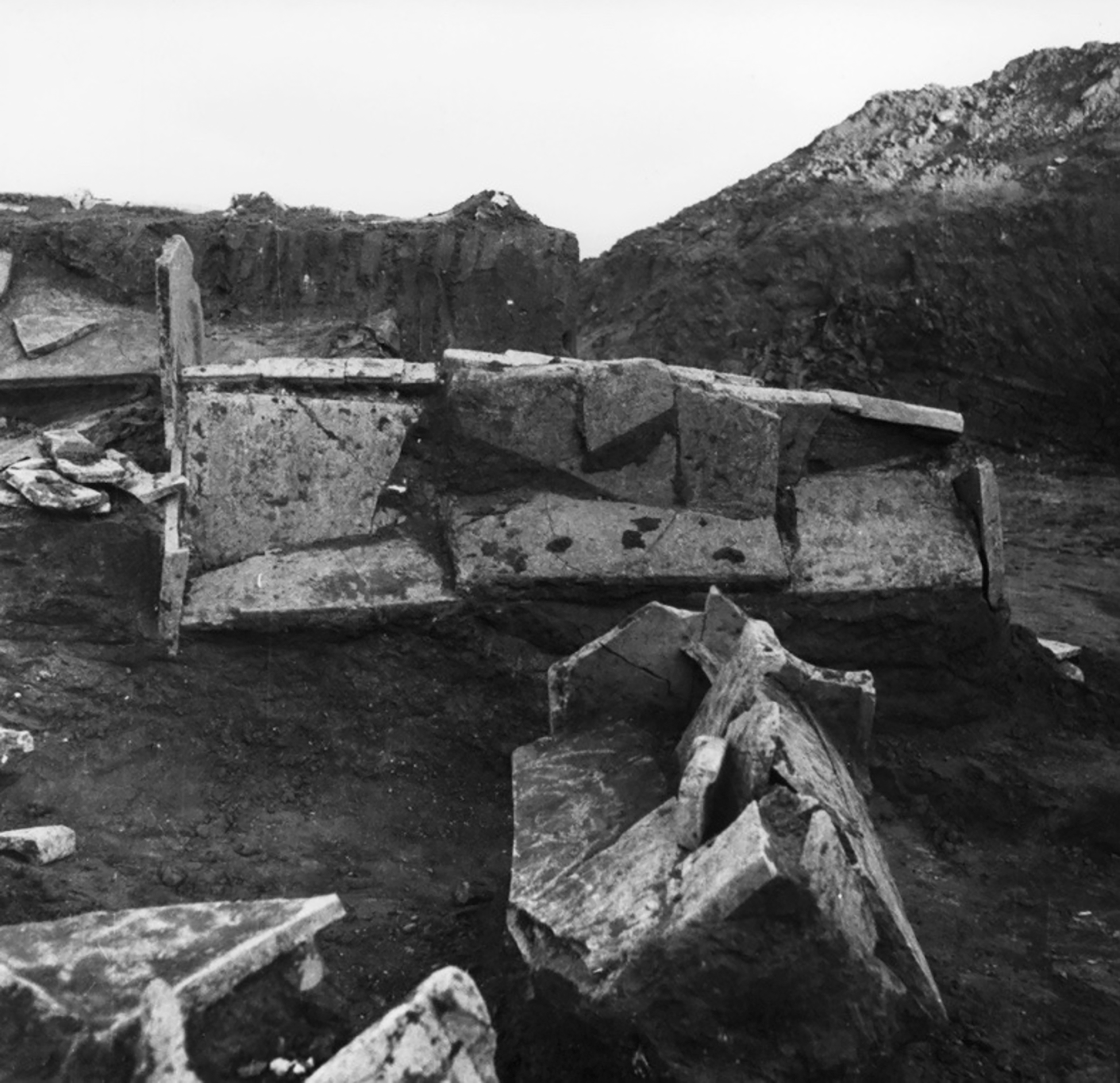 A black and white photograph of ancient tombs in a cemetery.
