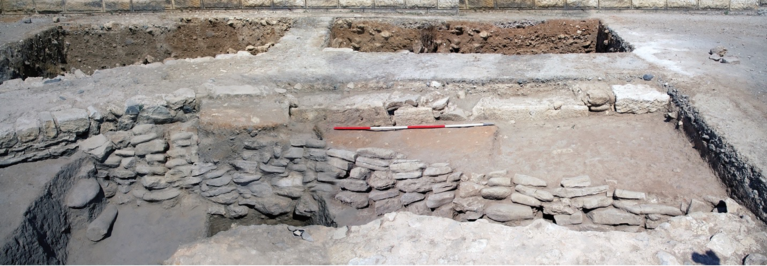 A cross-sectional view of an archaeological excavation showing different layers and structures.