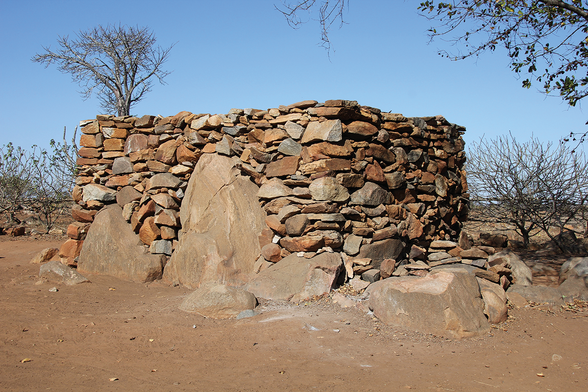 A stone-walled structure in a dry, arid landscape.