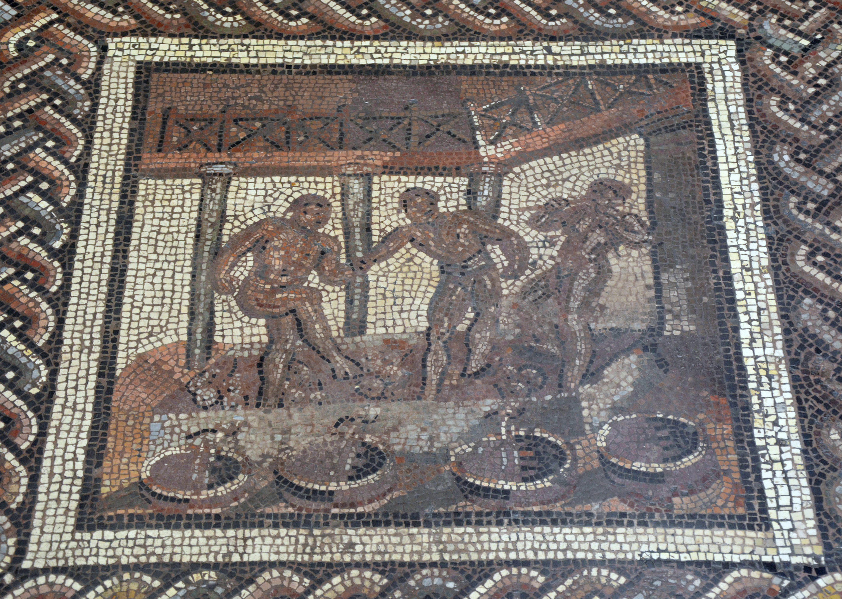 A mosaic depicting three Roman workers treading grapes.