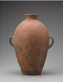 Photograph of a Sixth Dynasty Levantine amphora decorated on the exterior with combing. The vessel is handled and well-preserved.