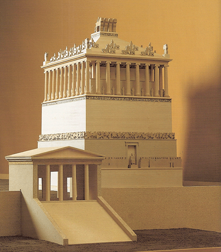 A model of the Mausoleum, a multi-level structure adorned with works of sculpture. At the top is a colonnade crowned by a stepped pyramid and a quadriga. It stands on a terrace reached by a stair leading to a small entrance building.